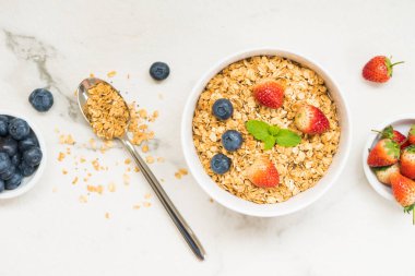 Sağlıklı kahvaltı Granola yaban mersini ve çilek ve siyah kahve, süt ve portakal suyu ile beyaz taş tablo arka planı ayarla