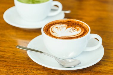 ahşap masa üzerinde beyaz fincan sıcak çikolatalı latte