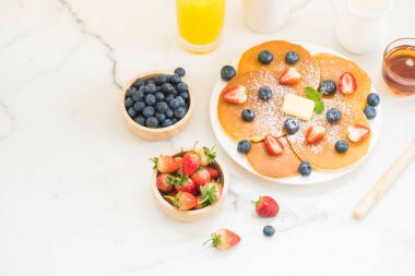 Sağlıklı kahvaltı gözleme yaban mersini ve çilek meyve ve siyah kahve, süt ve portakal suyu ile beyaz taş tablo arka plan üzerinde ayarla