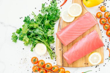 Sebze ve yemek pişirmek için madde ile ahşap kesme tahtası üzerinde ham ton balığı filetosu et