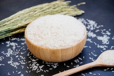 Raw Jasmine rice in wooden bowl  and spoon with grain and seed clipart