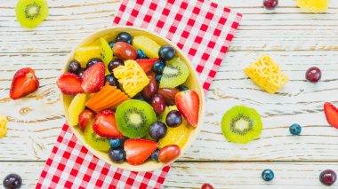 Kivi çilek üzüm ve diğer ahşap masa - filtre işleme üzerinde kase ile karışık ve çeşitli meyve