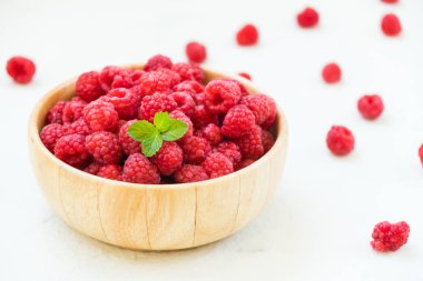 Kırmızı ahududu meyve masada ahşap kase