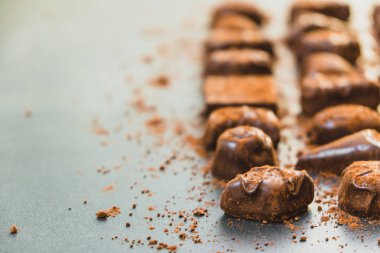 Şekerli tatlı koyu çikolata parçaları ve siyah taş zemin üzerine kakao tozu