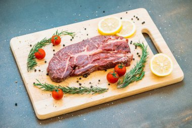 Kesme tahtası sebze ve yemek pişirmek için madde ile ham sığır eti