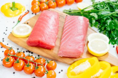Sebze ve yemek pişirmek için madde ile ahşap kesme tahtası üzerinde ham ton balığı filetosu et