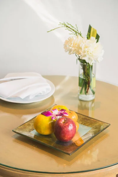 Welcome fruit in hotel bedroom with white flower in vase