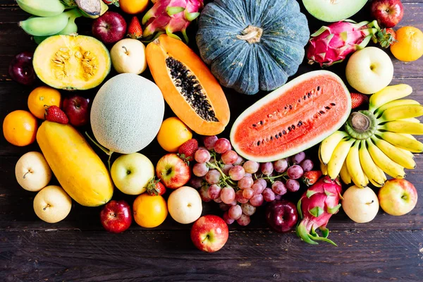 Assorted and mixed fruits on wooden background with copy space - Healthy food concept