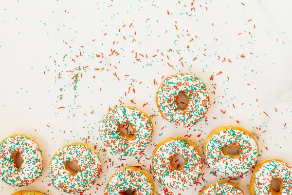 Donuts with white chocolate cream and sprinkles sugar on top - Unhealthy food style