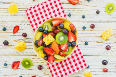 Kivi çilek üzüm ve diğer ahşap masa - filtre işleme üzerinde kase ile karışık ve çeşitli meyve