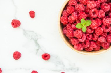 Kırmızı ahududu meyve masada ahşap kase