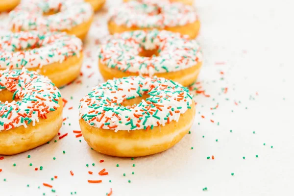 Donuts with white chocolate cream and sprinkles sugar on top - Unhealthy food style