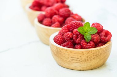 Kırmızı ahududu meyve masada ahşap kase