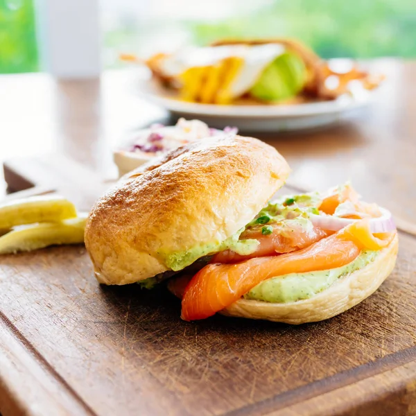 Bagel Bröd Med Rökt Lax Kött Och Grönsaker Trä Skärbräda — Stockfoto