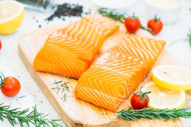 Ahşap kesme tahtası üzerinde ham ve taze somon eti fileto