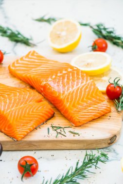 Ahşap kesme tahtası üzerinde ham ve taze somon eti fileto