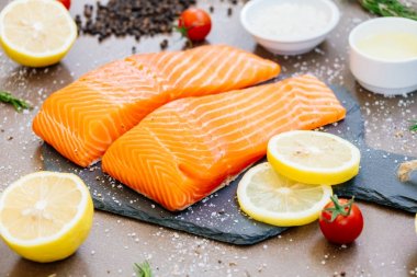 Ham ve taze somon eti fileto üzerinde siyah taş kayrak