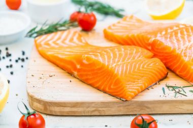 Ahşap kesme tahtası üzerinde ham ve taze somon eti fileto