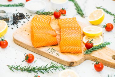 Ahşap kesme tahtası üzerinde ham ve taze somon eti fileto