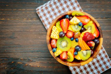 Kivi çilek üzüm ve diğer ahşap masa - filtre işleme üzerinde kase ile karışık ve çeşitli meyve