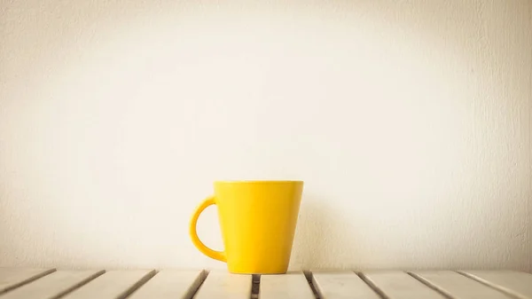 Žlutý šálek na stůl — Stock fotografie