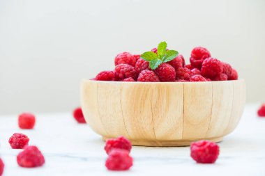 Kırmızı ahududu meyve masada ahşap kase