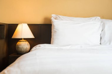 Yatakta ışık lamba ile beyaz rahat yastık