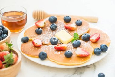 Sağlıklı kahvaltı gözleme yaban mersini ve çilek meyve ile taş tablo arka plan üzerinde ayarlayın.