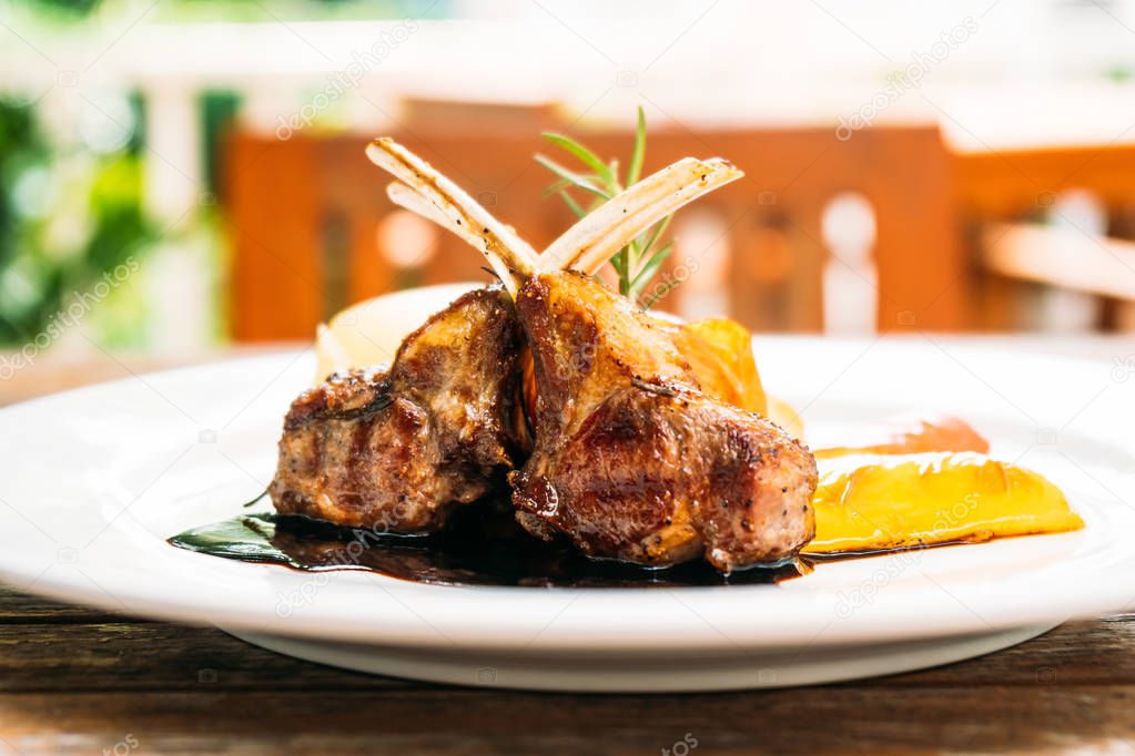 Grilled lamb chop steak with vegetable and sauce in white plate