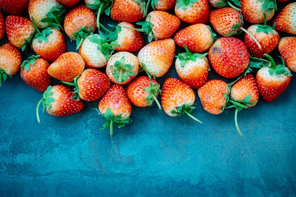 Strawberry fruit on black stone background with copy space