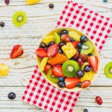 Kivi çilek üzüm ve diğer ahşap masa - filtre işleme üzerinde kase ile karışık ve çeşitli meyve