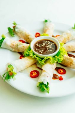 Et içinde bahar rulo beyaz tabakta sebze ve tatlı soslu ördek