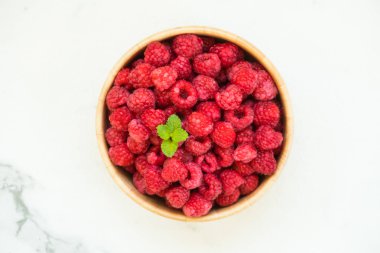 Kırmızı ahududu meyve masada ahşap kase