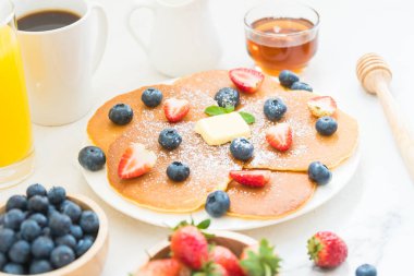 Sağlıklı kahvaltı gözleme yaban mersini ve çilek meyve ve siyah kahve, süt ve portakal suyu ile beyaz taş tablo arka plan üzerinde ayarla