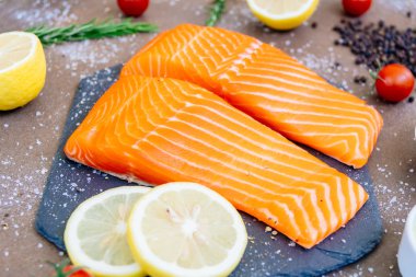 Siyah taş ham ve taze somon eti filetosu domates limon ve diğer madde - sağlıklı gıda tarzı ile kayrak