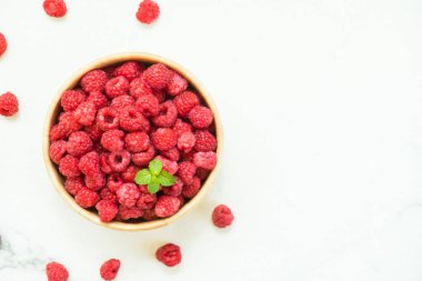 Kırmızı ahududu meyve masada ahşap kase