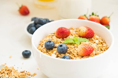 Sağlıklı kahvaltı Granola yaban mersini ve çilek ve siyah kahve, süt ve portakal suyu ile beyaz taş tablo arka planı ayarla