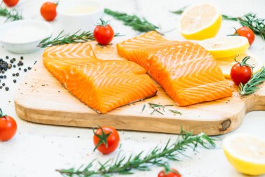 Limon domates ve diğer madde - sağlıklı gıda tarzı ahşap kesme tahtası üzerinde ham ve taze somon eti fileto
