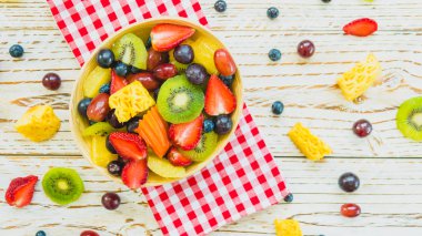 Kivi çilek üzüm ve diğer ahşap masa - filtre işleme üzerinde kase ile karışık ve çeşitli meyve