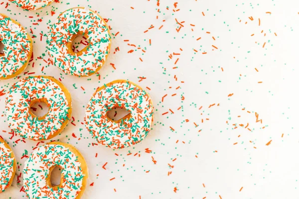 Donuts with white chocolate cream and sprinkles sugar on top - Unhealthy food style