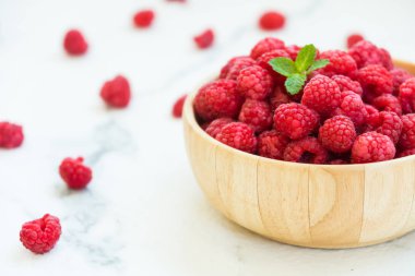 Kırmızı ahududu meyve masada ahşap kase