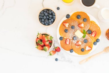 Sağlıklı kahvaltı gözleme yaban mersini ve çilek meyve ve siyah kahve, süt ve portakal suyu ile beyaz taş tablo arka plan üzerinde ayarla