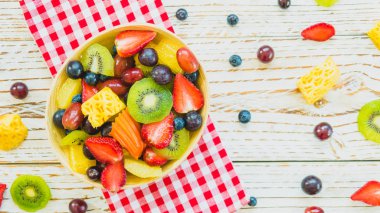 Kivi çilek üzüm ve diğer ahşap masa - filtre işleme üzerinde kase ile karışık ve çeşitli meyve