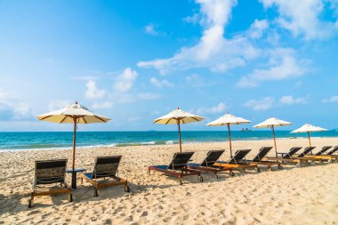 Şemsiye ve sandalye üzerinde plaj ve deniz