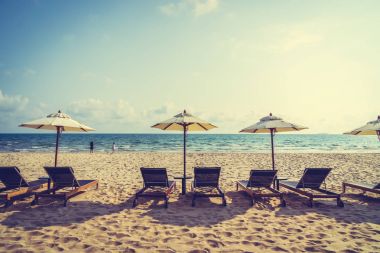 Şemsiye ve sandalye üzerinde plaj ve deniz