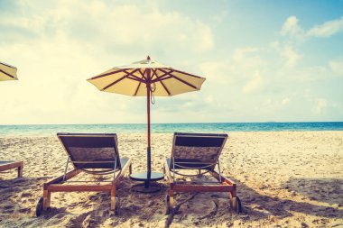 Şemsiye ve sandalye üzerinde plaj ve deniz