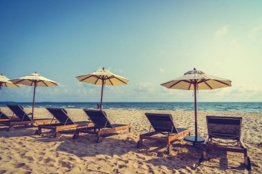 Şemsiye ve sandalye üzerinde plaj ve deniz