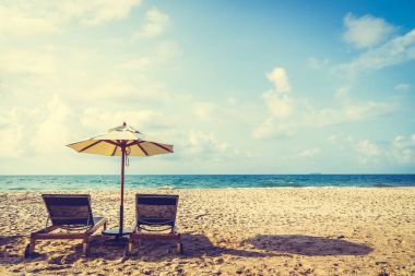Şemsiye ve sandalye üzerinde plaj ve deniz