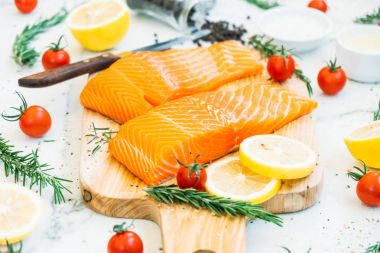Ahşap kesme tahtası üzerinde ham ve taze somon eti fileto