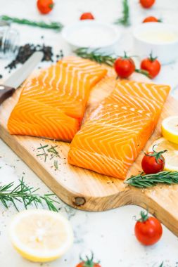 Ahşap kesme tahtası üzerinde ham ve taze somon eti fileto